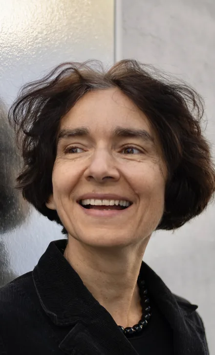 Porträt von Maria Laura Bono vor einer hellen Wand.